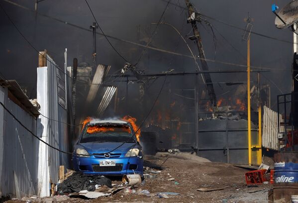 Горящий автомобиль во время мощного пожара в чилийском городе Икике. - Sputnik Молдова