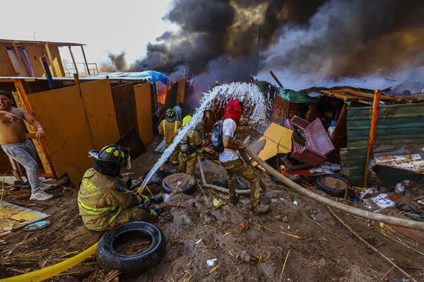 Тушение горящего дома в чилийском городе Икике. - Sputnik Молдова