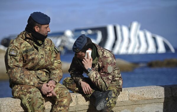 Soldați așezați în portul Isola del Giglio (insula Giglio), în fața navei de croazieră Costa Concordia naufragiată, făcută pe 23 ianuarie 2012. - Sputnik Moldova-România
