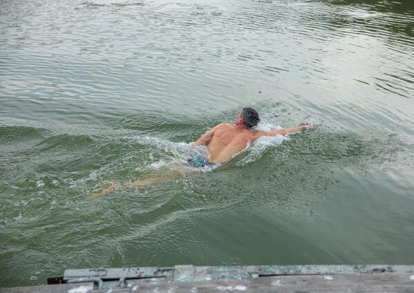 Un bărbat se scaldă în apa lacului Ghidighici - Sputnik Moldova