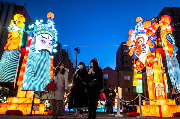 Oamenii trec pe lângă instalațiile de lanterne festive din Parcul Yamashitacho din Yokohama pe 16 ianuarie 2022, înainte de Anul Nou Lunar Chinezesc al Tigrului. - Sputnik Moldova-România