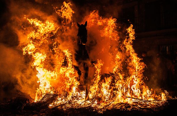 Мужчина едет на лошади через костер в Сан-Бартоломе-де-Пинарес, Испания. Традиция, которой сотни лет, призвана очистить и защитить животное в наступающем году. - Sputnik Молдова