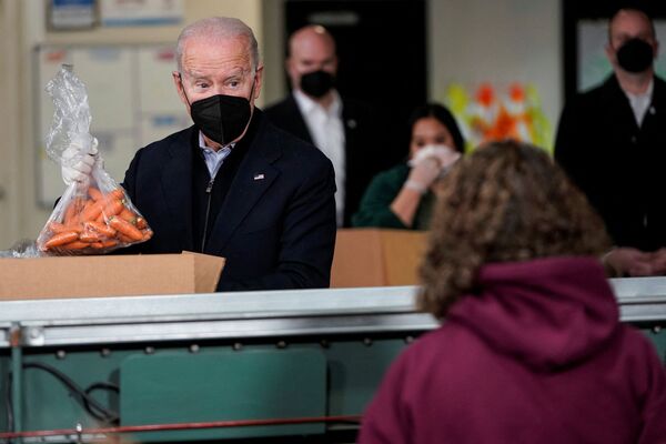 Президент США Джо Байден кладет пакет с морковью в ящик организации по оказанию помощи голодающим в Филадельфии, штат Пенсильвания, США. - Sputnik Молдова
