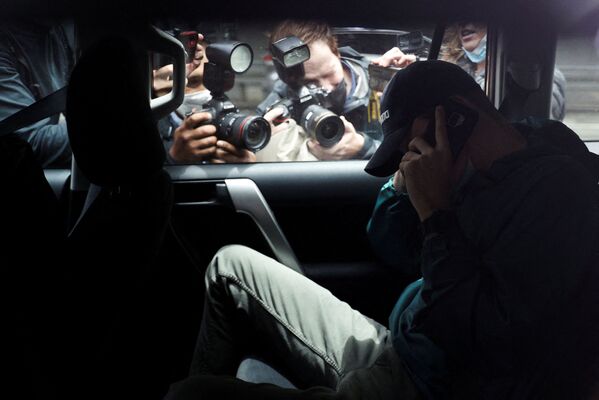 Представители СМИ фотографируют неизвестного мужчину, выезжающего с автостоянки у офиса юридической команды сербского теннисиста Новака Джоковича в сопровождении полиции в Мельбурне. - Sputnik Молдова