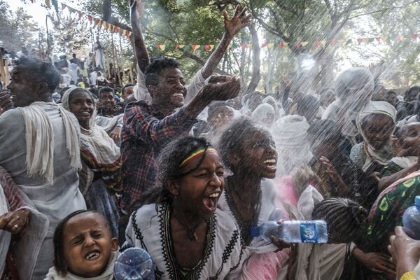 Эфиопские православные верующие окропляются водой на территории бани Фасилидес во время празднования Тимката. - Sputnik Молдова