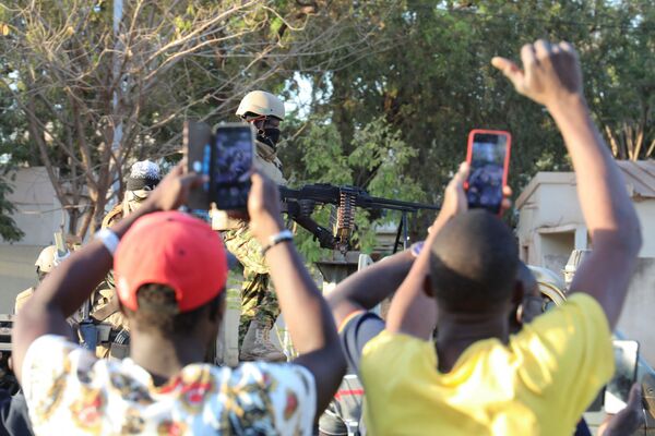 Oamenii își arată sprijinul față de armată după ce l-au detronat pe președintele Kabore în fața sediului televiziunii de stat RTB din Ouagadougou, Burkina Faso, 24 ianuarie 2022. - Sputnik Moldova-România