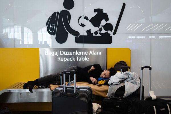 Pasageri blocați așteaptă pe aeroportul din Istanbul, unde zborurile sunt anulate din cauza viscolului și a ninsorilor abundente, în Istanbul, Turcia, pe 25 ianuarie 2022.  - Sputnik Moldova-România