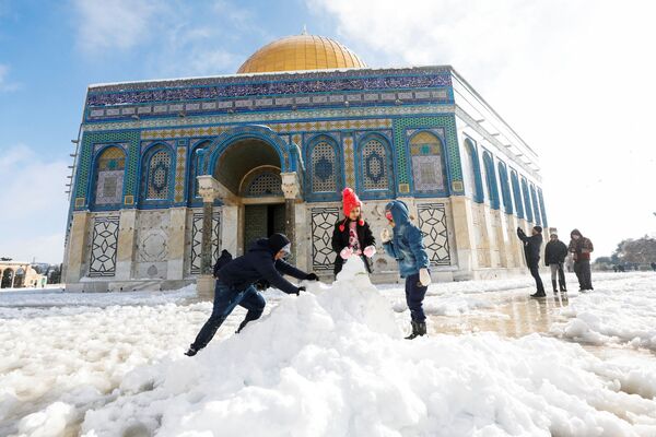 Дети лепят снеговика перед мечетью Купол Скалы, расположенной в Старом городе Иерусалима. - Sputnik Молдова