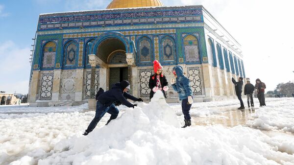Дети строят снеговика перед мечетью Купол Скалы, расположенной в Старом городе Иерусалима - Sputnik Молдова