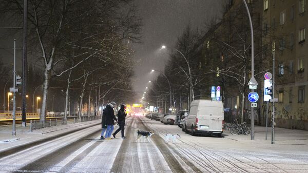 Люди переходят улицу после снегопада в Берлине, Германия - Sputnik Молдова