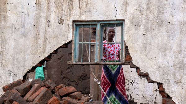 Женщина смотрит на свой дом, разрушенный тропическим штормом Ана в деревне Канджедза, Малави. - Sputnik Молдова