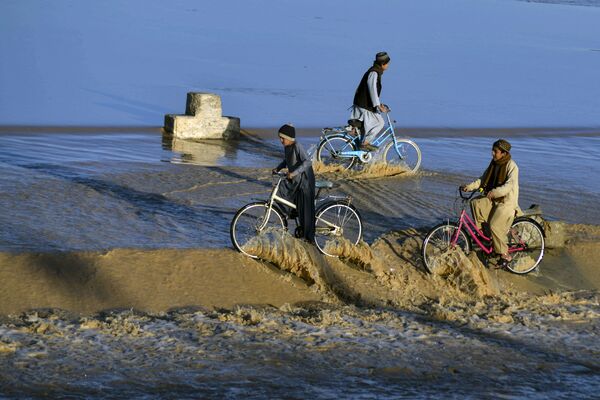 Мальчики катаются на велосипедах по паводковым водам в Кандагаре. - Sputnik Молдова