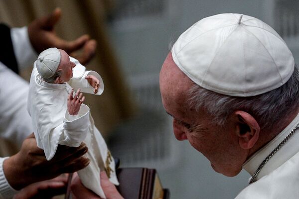 Папа Франциск смотрит на свою статуэтку в Ватикане. - Sputnik Молдова