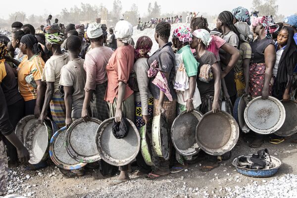 Женщины стоят в очереди за зарплатой на гранитной шахте в Уагадугу, Буркина-Фасо. - Sputnik Молдова