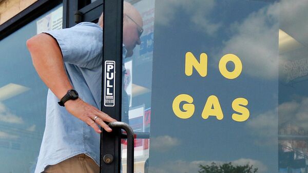 Покупатель заходит на заправочную станцию ​​Exxon и в магазин, где на двери висит табличка Без газа - Sputnik Moldova-România