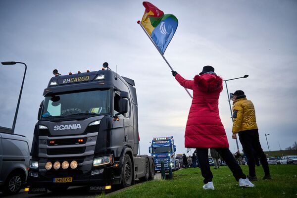 Suporterii aplaudă un grup de camionieri în timp ce părăsesc Stadionul ADO din Haga pe 13 februarie 2022, după ce s-au mutat pe stadion în urma așa-numitei demonstrații Freedom Convoy Netherlands și au petrecut noaptea acolo. - Sputnik Moldova-România