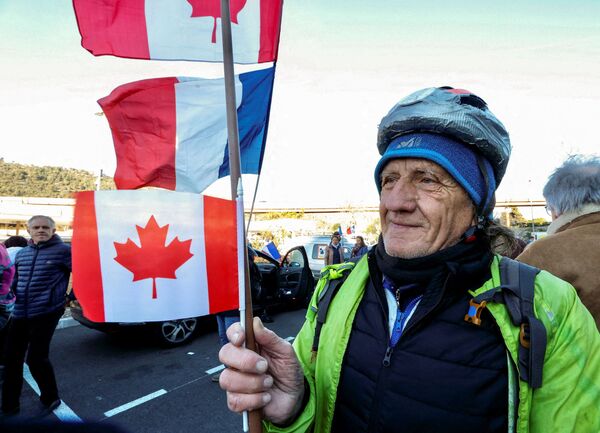 Un activist francez ține un steag canadian înainte de începerea „Convoi de la liberte” (Convoiul Libertății), un protest de convoi de vehicule care converge la Paris pentru a protesta împotriva vaccinului împotriva coronavirusului (COVID-19) și a restricțiilor din Nisa, Franța, 9 februarie. , 2022. - Sputnik Moldova-România