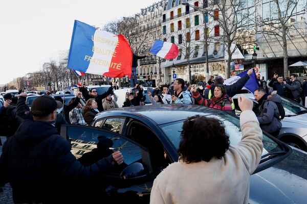 Protestatarii flutură steaguri franceze pe bulevardul Champs-Elysees în timp ce mașinile defilează în timpul „Convoi de la liberte” (Convoiul Libertății), un convoi de vehicule pentru a protesta împotriva vaccinului împotriva coronavirusului (COVID-19) și a restricțiilor din Paris, Franța, 12 februarie, 2022. - Sputnik Moldova-România