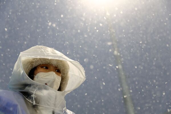 Олимпийский чиновник под снегопадом наблюдает за Играми. - Sputnik Молдова