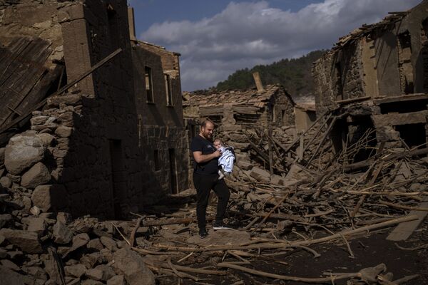 Мужчина показывает своему маленькому сыну развалины затопленной деревни. - Sputnik Молдова