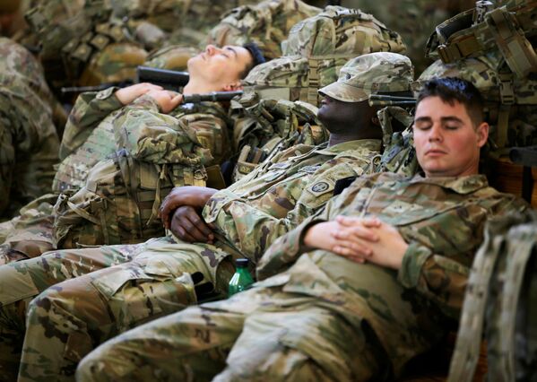 Soldații din Divizia 82 Aeropurtată a Armatei SUA se odihnesc în timp ce așteaptă să se îmbarce într-un avion de transport cu destinația Europa, la Fort Bragg, Carolina de Nord, SUA, 14 februarie 2022. - Sputnik Moldova-România