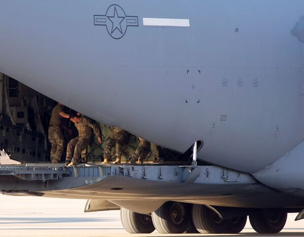 Soldații armatei americane încarcă cargo într-o aeronavă C-17 a forțelor aeriene americane în apropierea locului în care parașutiștii Diviziei Aeropurtate a 82-a se îmbarcă într-un avion de transport cu destinația Europa, la Fort Bragg, Carolina de Nord, SUA, 14 februarie 2022. - Sputnik Moldova-România