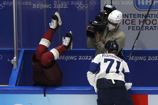 Латвийский хоккеист Увис Балинскис вылетает за борт во время матча с Финляндией. - Sputnik Молдова