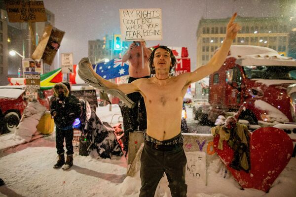 Протест против ограничений, вызванных пандемией коронавируса, в Оттаве, Канада. Мужчина держит в руках плакат с надписью &quot;Мои права не заканчиваются там, где начинается ваш страх&quot;. - Sputnik Молдова