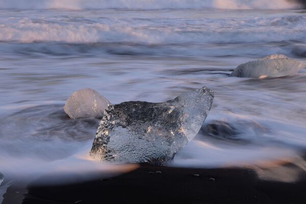Глыбы льда, отколовшиеся от ледниковой лагуны Йокульсарлон, видны на Даймонд-Бич зимой на южном побережье Исландии. - Sputnik Молдова
