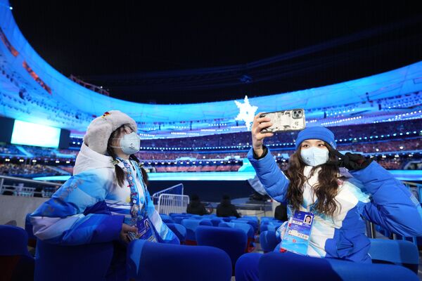Волонтеры фотографируются на Национальном стадионе перед началом церемонии закрытия XXIV зимних Олимпийских игр. - Sputnik Молдова