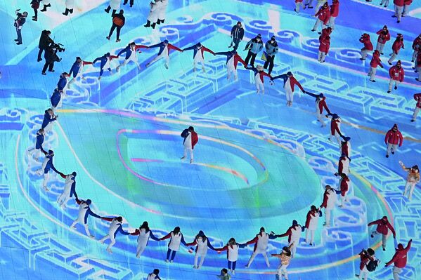 Sportivii dansează în cerc la intrarea pe Stadionul Olimpic pentru ceremonia de încheiere a Jocurilor Olimpice de iarnă din 2022, duminică, 20 februarie 2022, la Beijing. - Sputnik Moldova-România