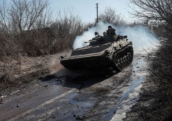 Membrii serviciilor ucrainene călătoresc cu un vehicul de luptă al infanteriei pe linia frontului, lângă satul Zaițevo din regiunea Donețk, Ucraina, 19 februarie 2022 - Sputnik Moldova-România