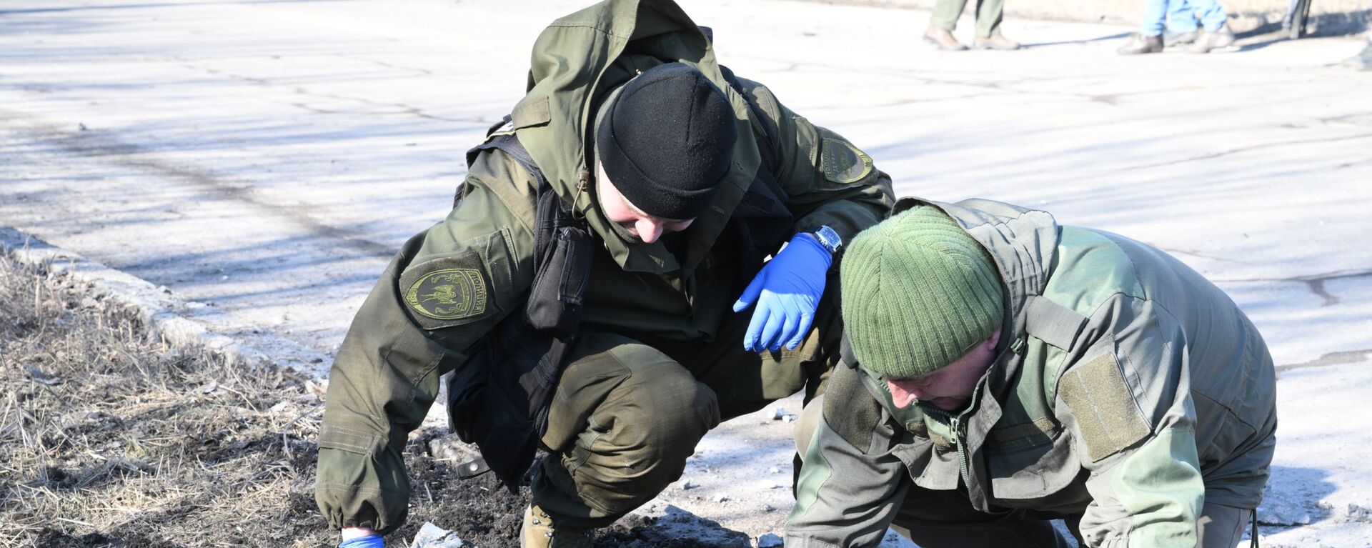 Сотрудники народной милиции ДНР осматривают место взрыва в Петровском районе Донецка после обстрела - Sputnik Молдова, 1920, 22.02.2022