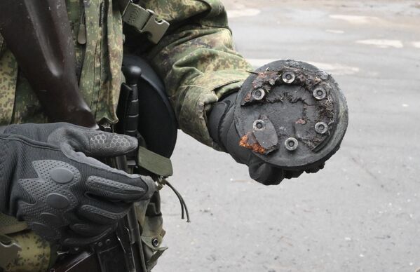 Un militar demonstrează un element al unei rachete Tochka-U tras într-un depozit de petrol din districtul Kirovsky din Donețk. RPD a spus că trupele ucrainene au tras 4 rachete Tochka-U pe teritoriul lor într-o zi. - Sputnik Moldova-România