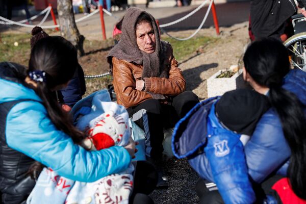 Oameni care fug din Ucraina în Ungaria, la Zahony, 27 februarie 2022, așteaptă să fie transferați într-un adăpost, după ce Rusia a lansat o operațiune militară masivă în Ucraina. - Sputnik Moldova-România