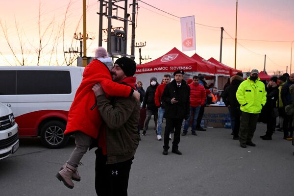 Un copil care fuge din Ucraina îmbrățișează o rudă după ce a ajuns în Slovacia, la Vysne Nemecke, Slovacia, 26 februarie 2022, după ce Rusia a lansat o operațiune militară masivă în Ucraina. - Sputnik Moldova-România
