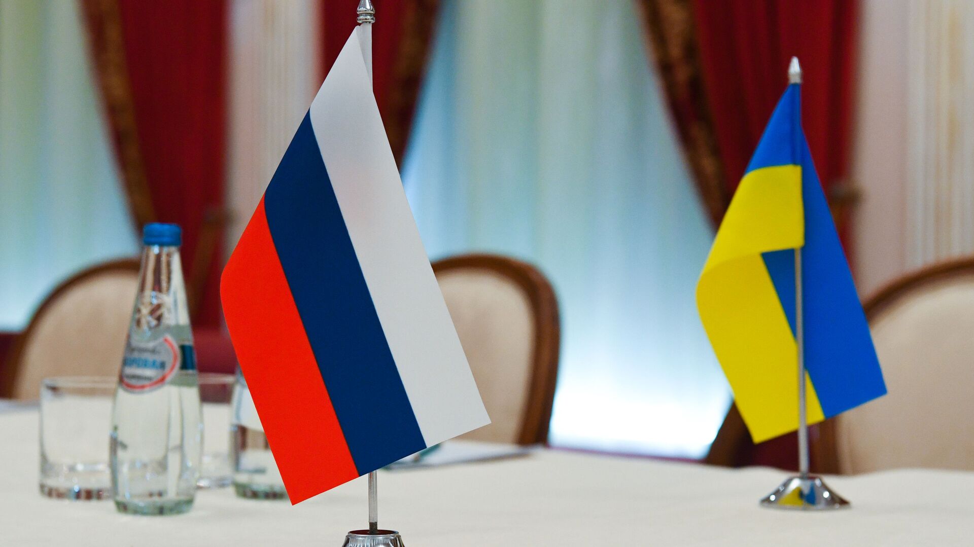 Флаги России и Украины в зале, где пройдут переговоры - Sputnik Moldova-România, 1920, 01.03.2022