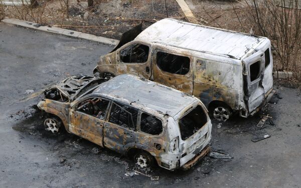Mașini arse în curtea unei clădiri rezidențiale cu mai multe etaje din Donețk, distruse de bombardamente. - Sputnik Moldova-România