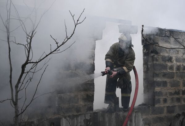 Pompierii din Donețk sting un incendiu într-o clădire rezidențială de pe strada Parkovskaya din Donețk, distrusă de bombardamente. - Sputnik Moldova-România