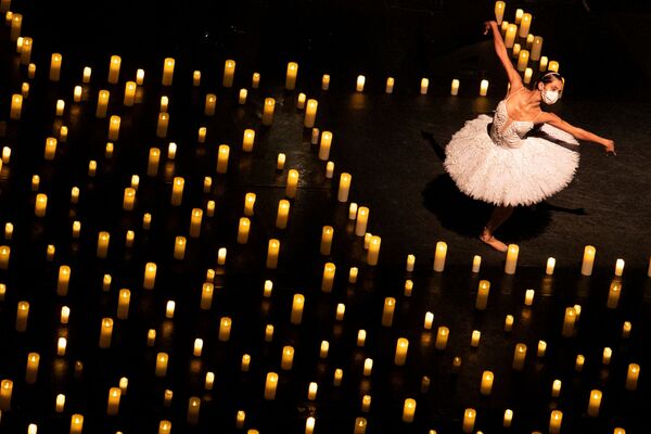 Балерина танцует среди свечей во время концерта Candlelight в Сан-Паулу, Бразилия. - Sputnik Молдова