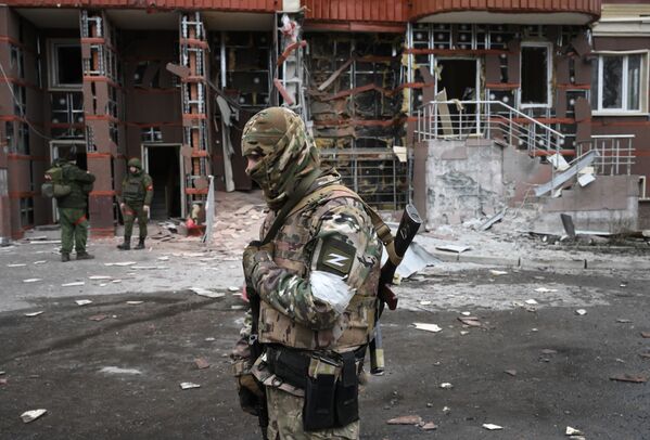 Военнослужащие во дворе многоэтажного жилого дома в Донецке, поврежденного в результате обстрела - Sputnik Молдова
