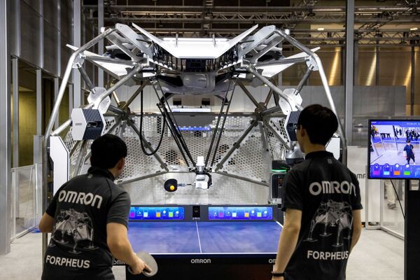 Робот для настольного тенниса (C), разработанный производителем деталей для автоматизации Omron, отбивает мяч игроку во время демонстрации на Международной выставке роботов в Токио 9 марта 2022 года. - Sputnik Молдова