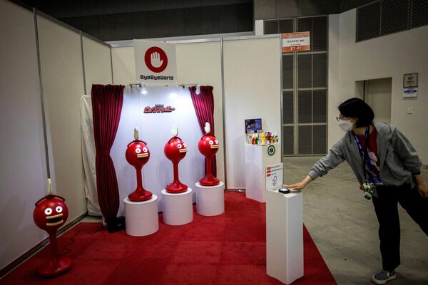 Сотрудник демонстрирует роботов Big Clapper, разработанных Bye Bye World Inc., на Международной выставке роботов в Токио 9 марта 2022 года. - Sputnik Молдова