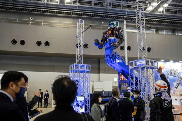 Робот Jinki type Zero ver.2.0 (вверху), разработанный компанией Man-Machine Synergy Effectors Inc., демонстрируется посетителям на Международной выставке роботов в Токио 9 марта 2022 года. - Sputnik Молдова
