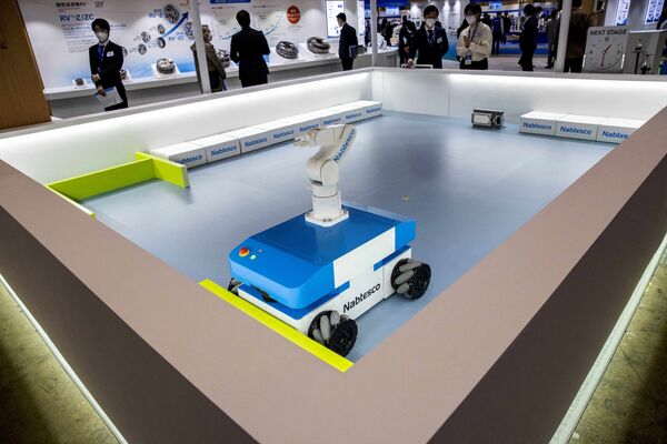 Посетители смотрят на демонстрацию привода AGV RVW, разработанного Nabtesco, на Международной выставке роботов в Токио 9 марта 2022 года. - Sputnik Молдова