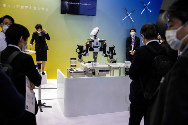 Посетители наблюдают за демонстрацией гуманоидного робота Nextage, разработанного Kawada Robotics, на Международной выставке роботов в Токио 9 марта 2022 года. - Sputnik Молдова