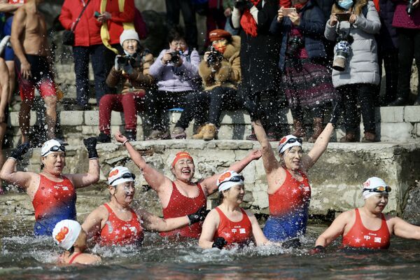Группа энтузиастов зимнего плавания, состоящая исключительно из женщин, плавает в частично замерзшем озере во время празднования Международного женского дня в Шэньяне, провинция Ляонин на северо-востоке Китая, 8 марта 2022 года. - Sputnik Молдова
