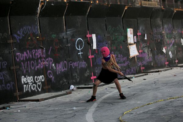 O femeie aruncă moloz spre un gard în timpul unui protest pentru a marca Ziua Internațională a Femeii, în Mexico City, Mexic, 8 martie 2022. - Sputnik Moldova-România
