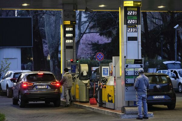 Un angajat modifică prețurile la carburanți pe panoul de afișaj la o benzinărie din Milano, Italia, 10 martie 2022. Prețul la combustibil pentru automobilele din Italia a depășit recent pragul de 2,00 euro pe litru, fiind înregistrat un record  maxim de 2,40 euro pe litru. - Sputnik Moldova-România