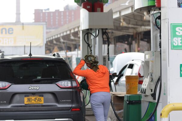 O persoană fiind la pompă la o benzinărie în timp ce prețurile combustibilului au fost modificate în Manhattan, New York City, 7 martie 2022. - Sputnik Moldova-România